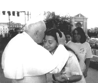 Pope John Paul II kissing the forehead of a young woman